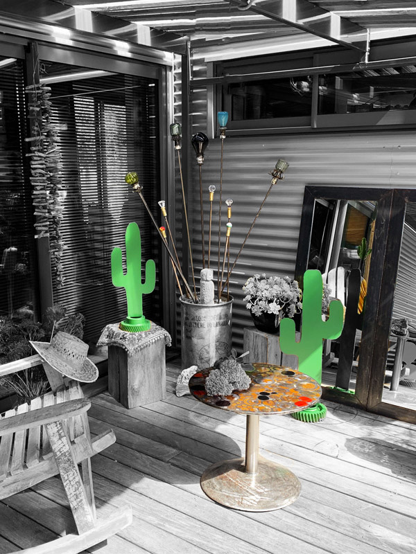 Vue d'ensemble, jardin d'hiver, déco métal. Cactus décoratifs en métal, table basse en métal rouillé et pâte de verre rouge et noir, miroir cadre métal brut et sceptres décoratif en pièces métalliques de récupération et verre. Créations déco métal Art-Twin